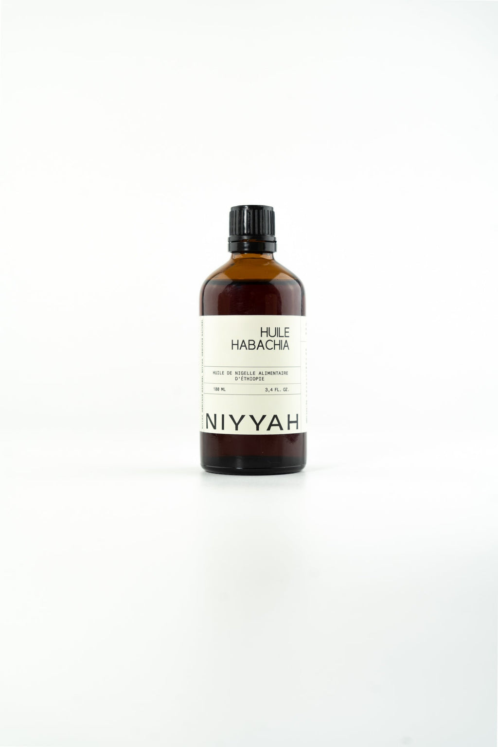 Flacon verre ambré d'huile de nigelle Habacha pure 100ml alimentaire pressée à froid origine Éthiopie sur fond blanc