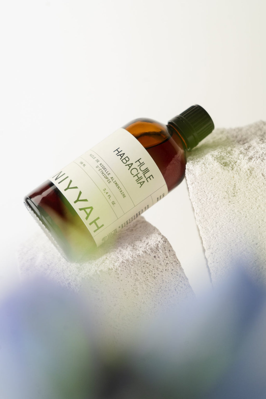 Huile de nigelle Habacha d'Éthiopie 100ml posée sur pierre naturelle avec reflet minimaliste